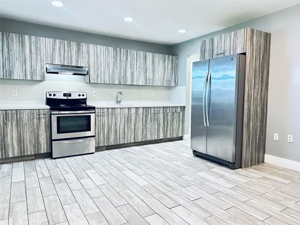 a kitchen with stainless steel appliances granite countertop a refrigerator a stove a sink and a cabinets