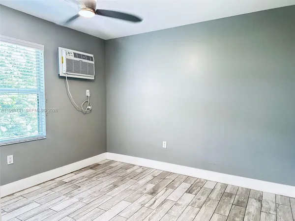 a view of a livingroom with wooden floor and a window