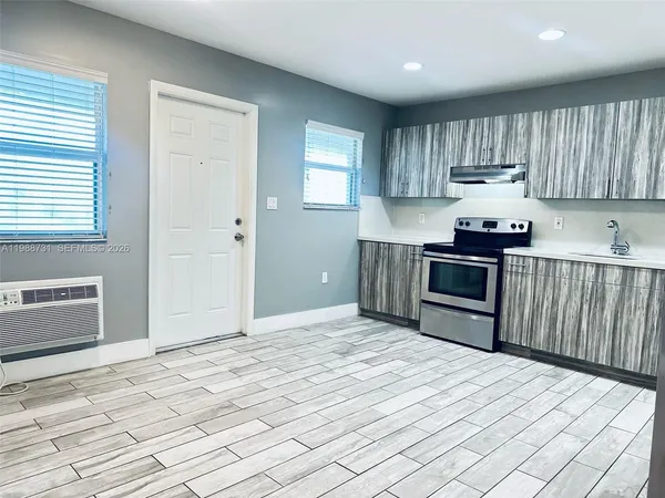 a kitchen with a stove sink and cabinets