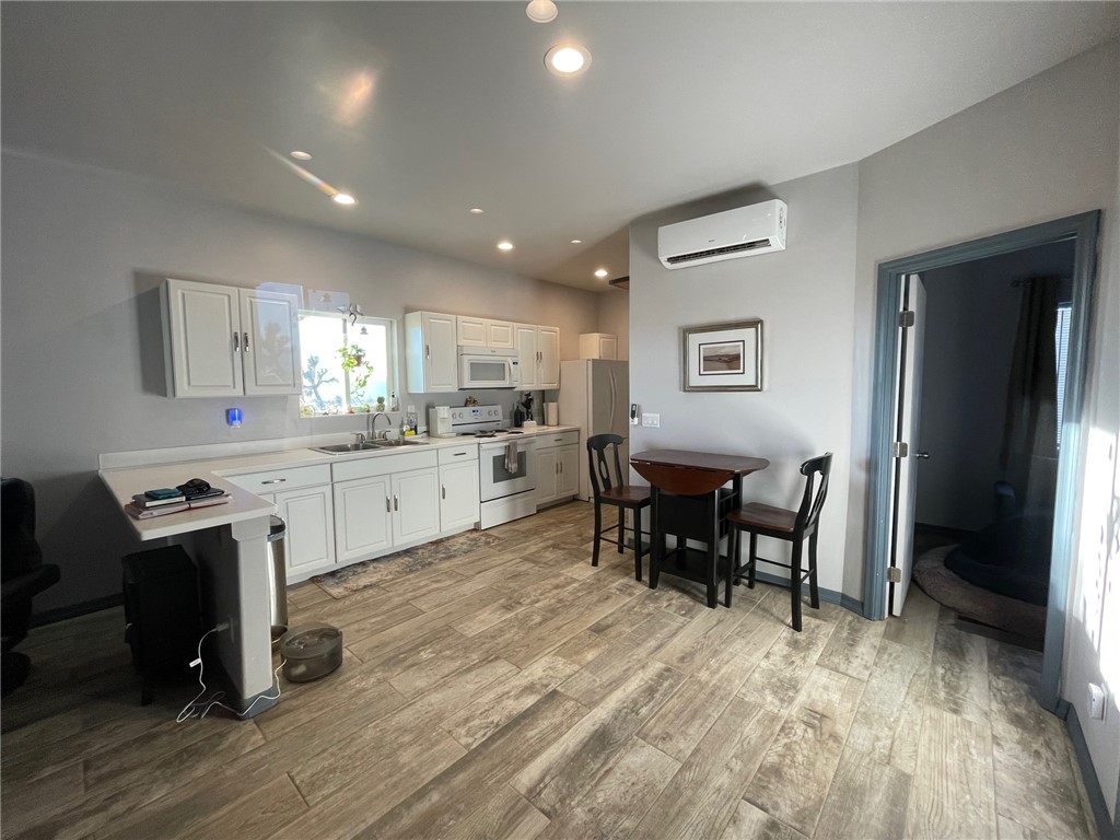 11328 Kinard Road Yucca, AZ 86438 - Photo 11 of 40 a kitchen with stainless steel appliances granite countertop dining table chairs a refrigerator and cabinets