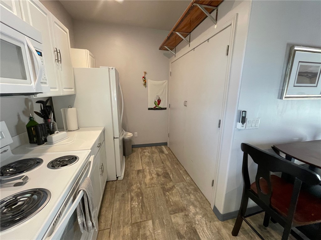 11328 Kinard Road Yucca, AZ 86438 - Photo 14 of 40 a kitchen with a refrigerator a stove and a wooden floor