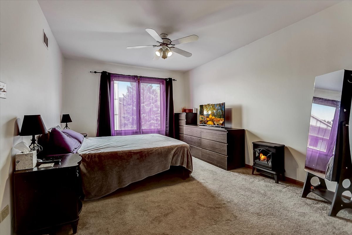 2317 Olde Mill Road Plainfield, IL 60586 - Photo 12 of 35 a bedroom with a bed and a chandelier