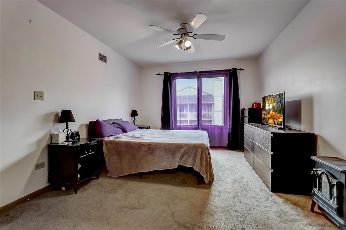 2317 Olde Mill Road Plainfield, IL 60586 - Photo 13 of 35 a spacious bedroom with a bed and a chandelier
