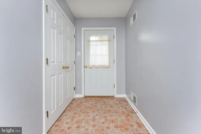 a view of a hallway with wooden floor and closet