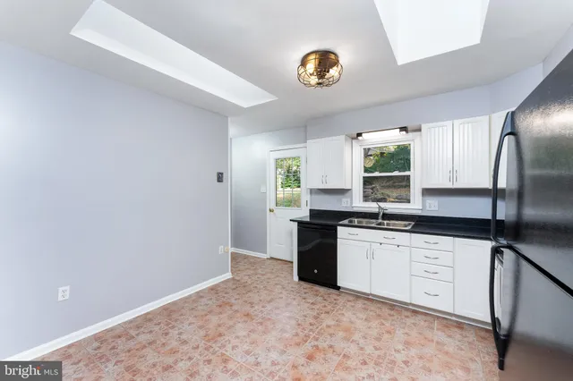 a kitchen with granite countertop a sink stainless steel appliances and cabinets