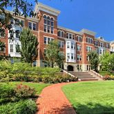 a front view of a building with a garden and plants