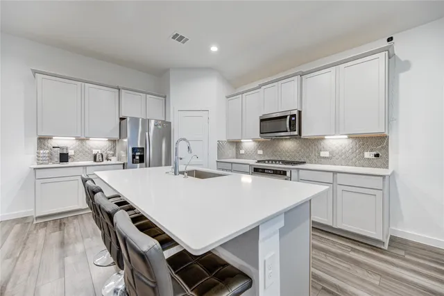 a kitchen with kitchen island a stove a sink and a refrigerator