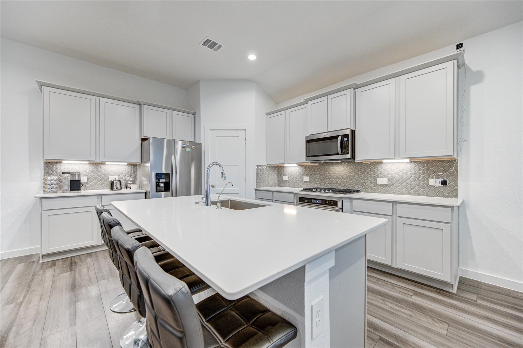22515 Modica Rift Lane Katy, TX 77449 - Photo 18 of 34 a kitchen with kitchen island a stove a sink and a refrigerator