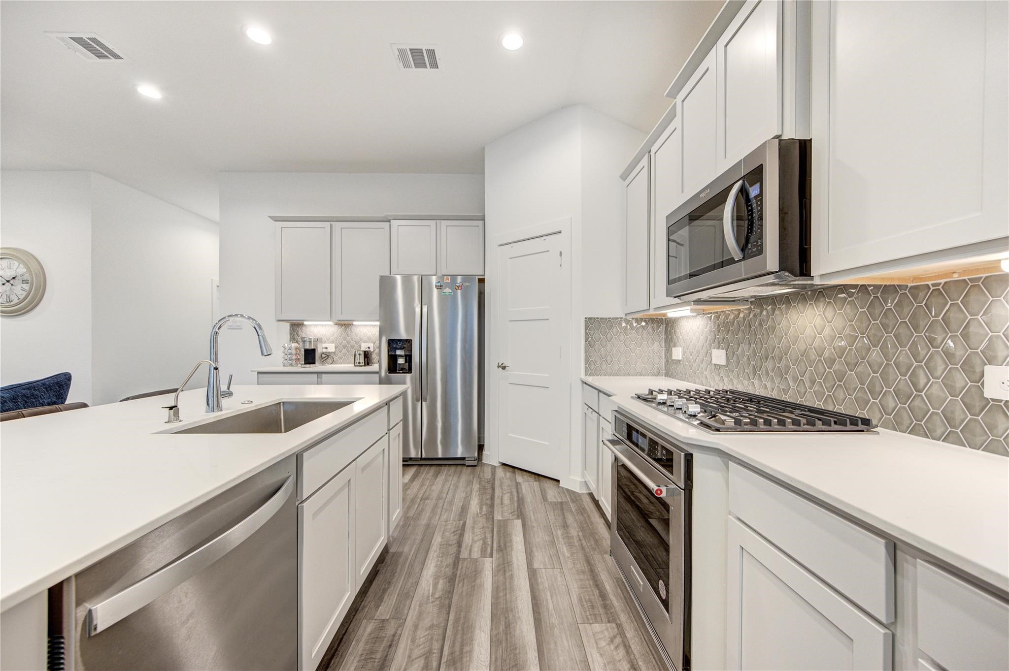 22515 Modica Rift Lane Katy, TX 77449 - Photo 19 of 34 a kitchen with a sink stove and cabinets
