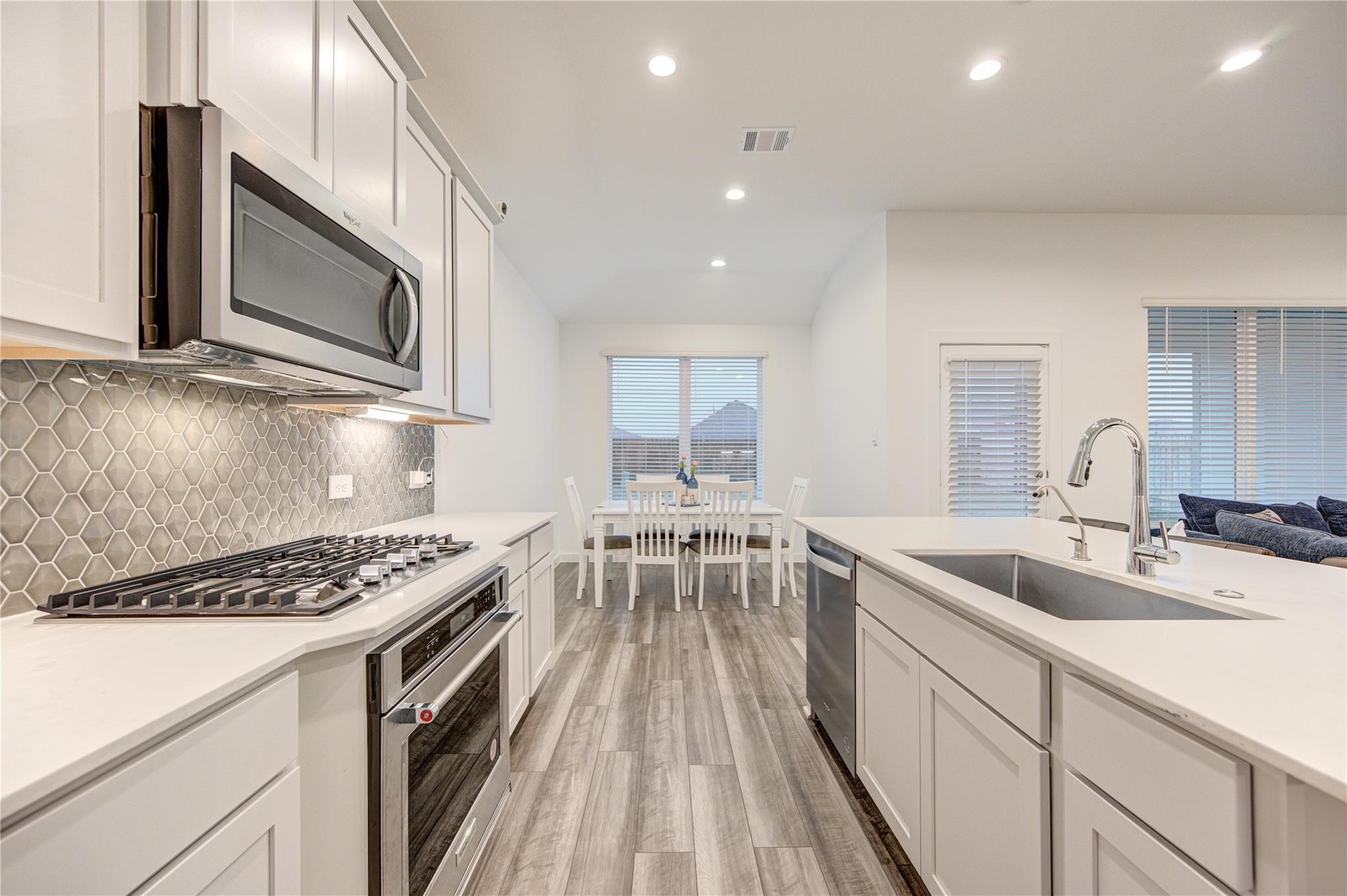22515 Modica Rift Lane Katy, TX 77449 - Photo 23 of 34 a kitchen with stainless steel appliances granite countertop a sink stove and microwave