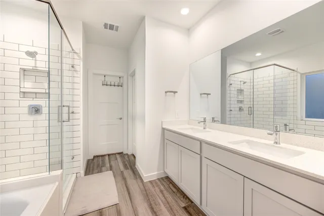 a bathroom with a double vanity sink and mirror with shower