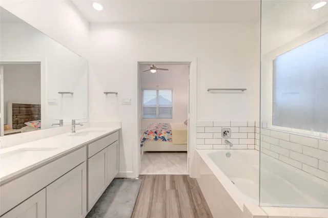 a spacious bathroom with a tub sink and mirror