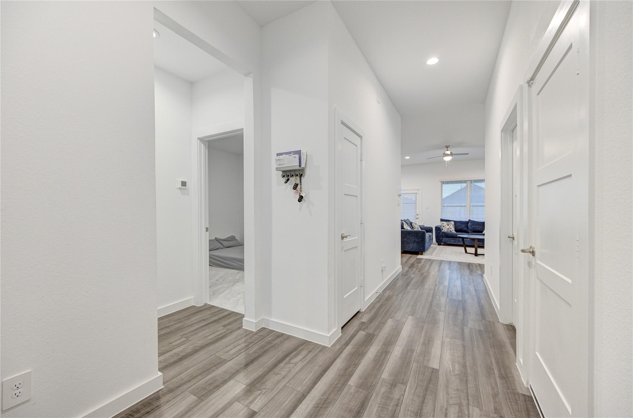 22515 Modica Rift Lane Katy, TX 77449 - Photo 7 of 34 a view of a hallway with wooden floor and a bathroom