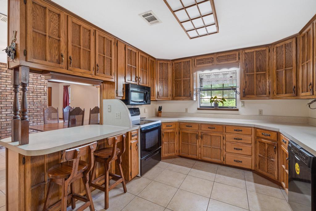 710 Ridge Lake Road Crestview, FL 32536 - Photo 29 of 43 a kitchen with stainless steel appliances granite countertop a stove a sink dishwasher and a microwave oven with cabinets