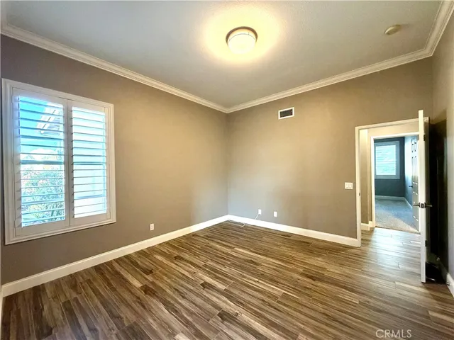 a view of empty room with wooden floor