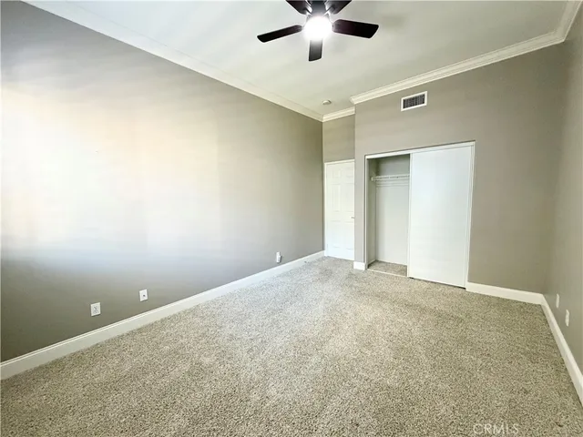 an empty room with a ceiling fan and a window
