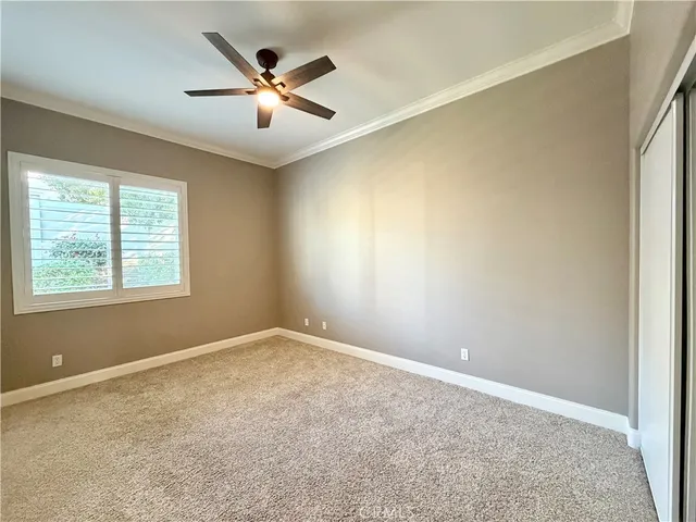 an empty room with ceiling fan and window