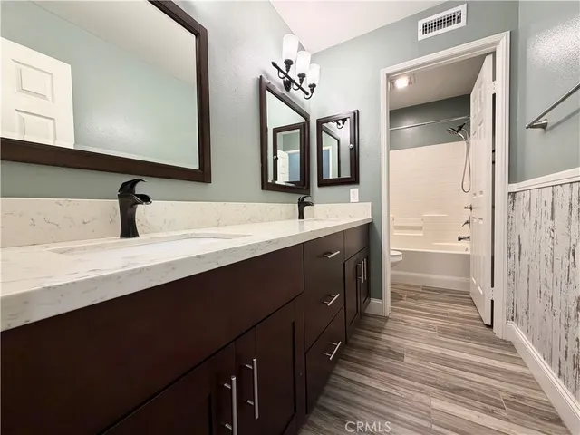 a bathroom with a double vanity sink and a mirror