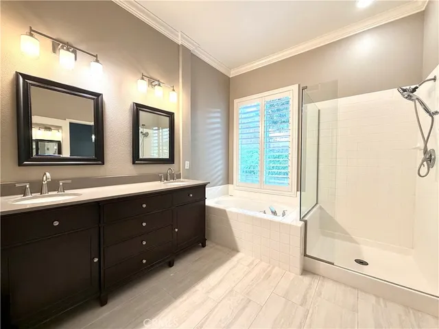 a bathroom with a granite countertop double vanity sink and a mirror
