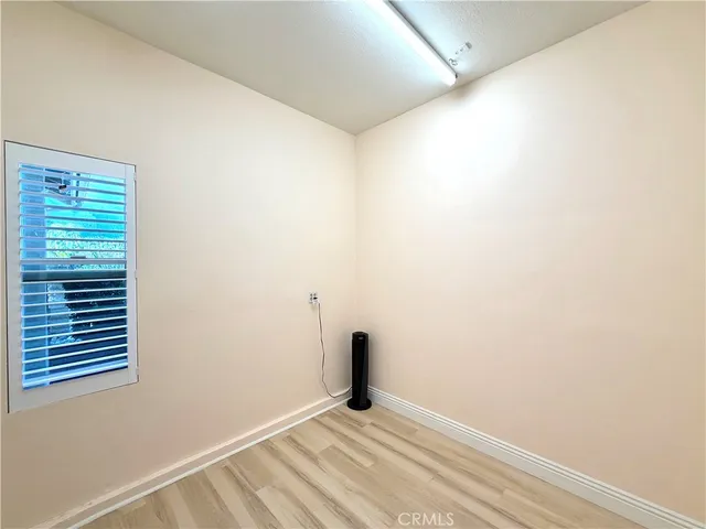 a view of an empty room with closet and a window