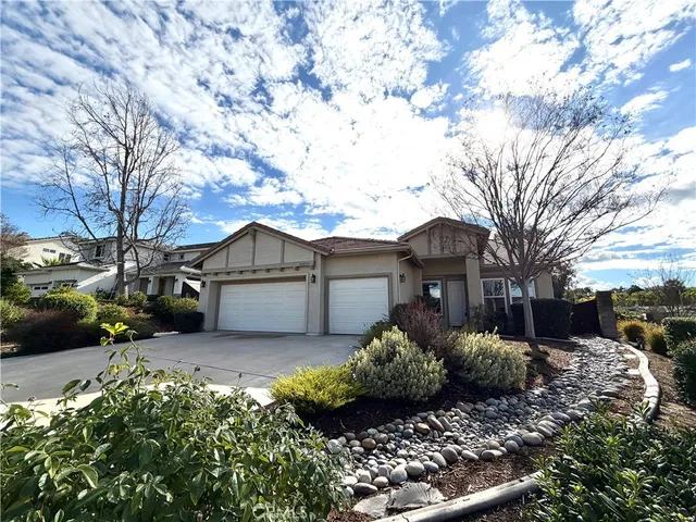a view of a house with a large tree and a yard