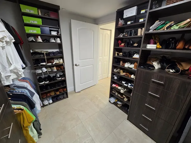 walk in closet with clothes and shoes