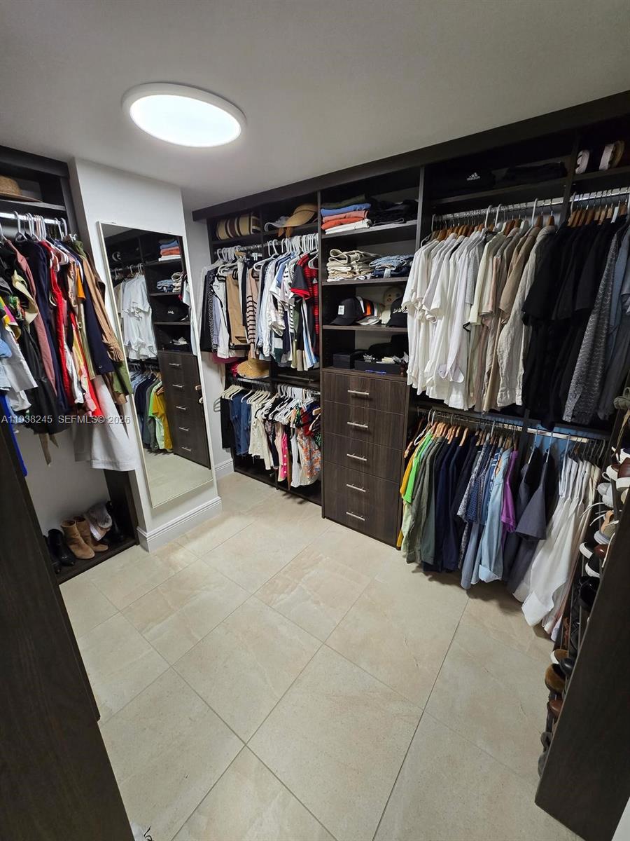 7350 Southwest 89th Street, Unit 907S Miami, FL 33156 - Photo 17 of 19 a view of walk in closet with clothes and shoes