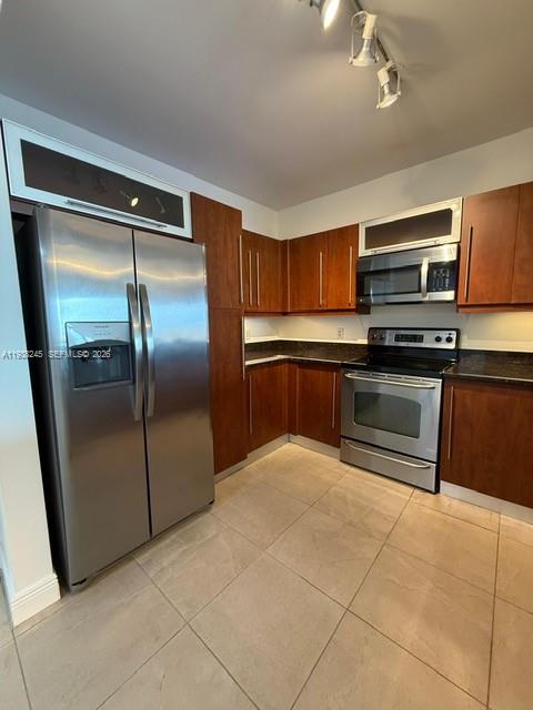7350 Southwest 89th Street, Unit 907S Miami, FL 33156 - Photo 6 of 25 a kitchen with granite countertop a refrigerator and a stove top oven