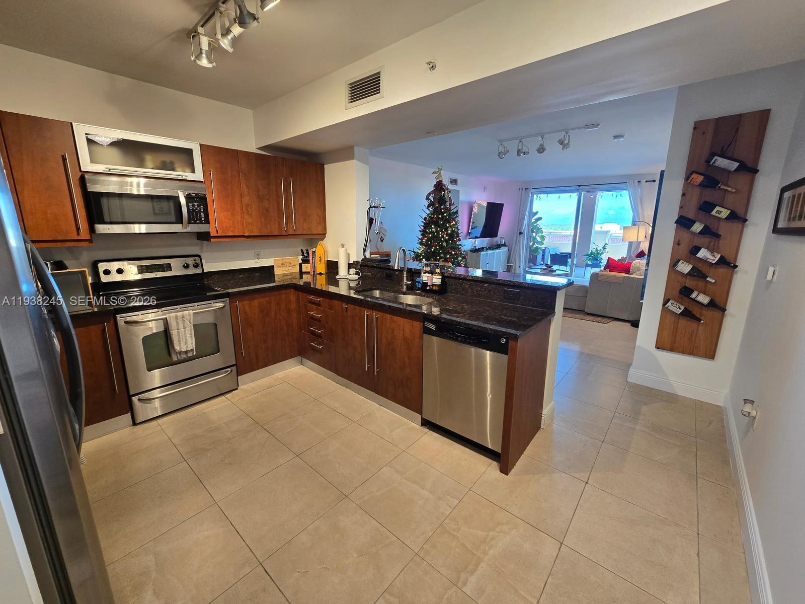 7350 Southwest 89th Street, Unit 907S Miami, FL 33156 - Photo 6 of 19 a kitchen with stainless steel appliances granite countertop a stove top oven a sink dishwasher and cabinets