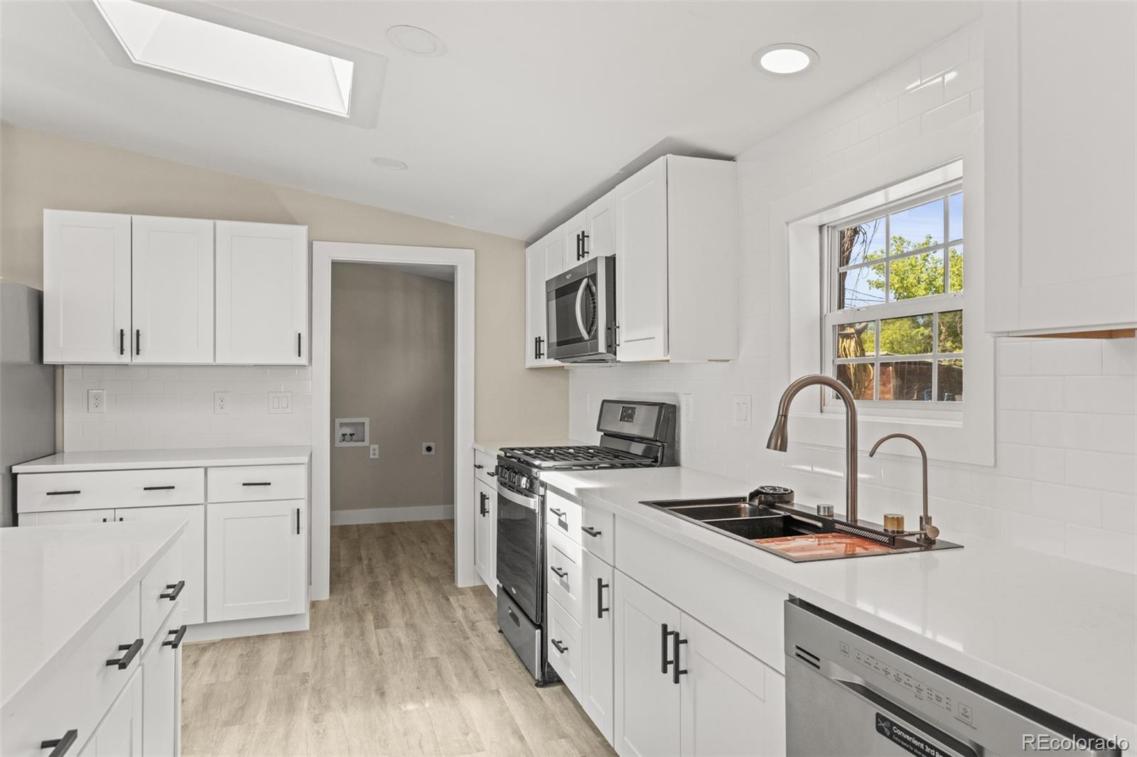 661 South Raleigh Street Denver, CO 80219 - Photo 3 of 19 a kitchen with cabinets a sink and appliances
