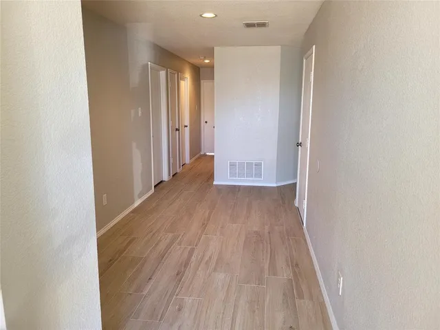a view of a hallway with wooden floor