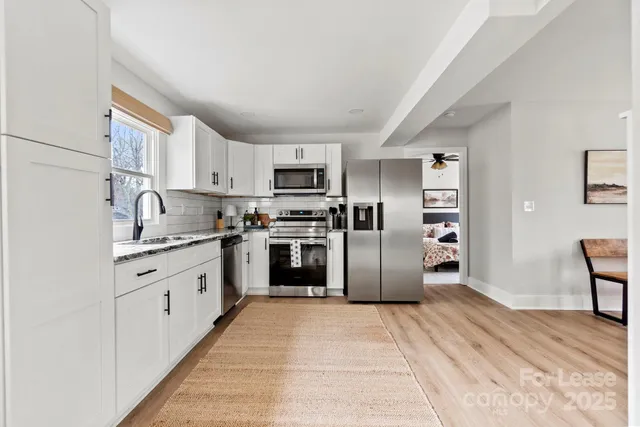 a kitchen with granite countertop a refrigerator stove top oven and sink