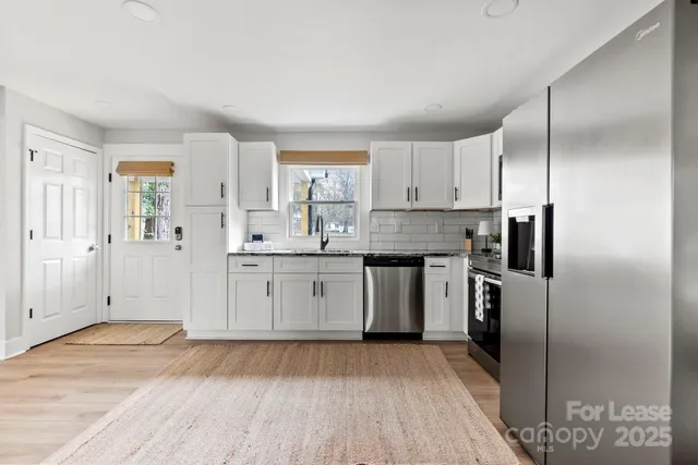 a kitchen with a refrigerator sink and cabinets