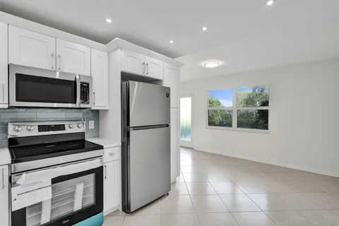 a kitchen with a refrigerator and a stove top oven