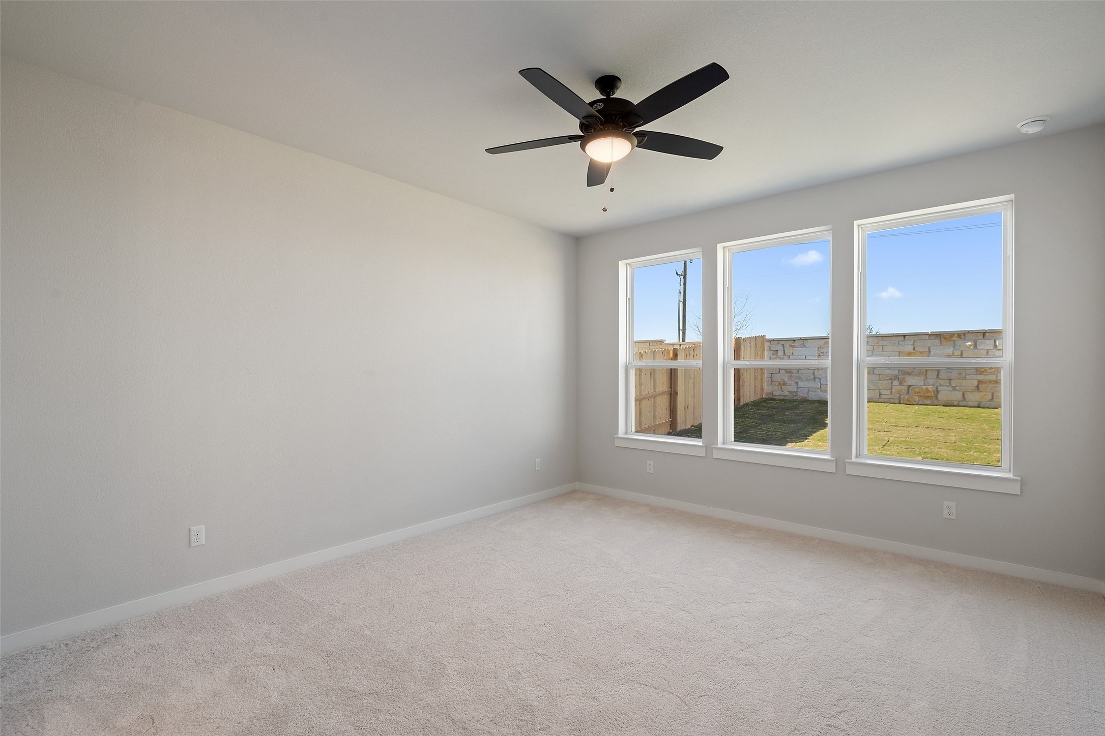 228 Brandywine Road Hutto, TX 78634 - Photo 23 of 40 an empty room with a ceiling fan and windows