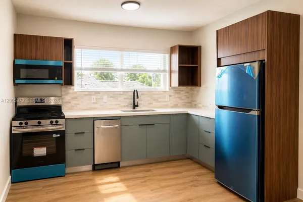 a kitchen with stainless steel appliances granite countertop a refrigerator a stove a sink and a microwave