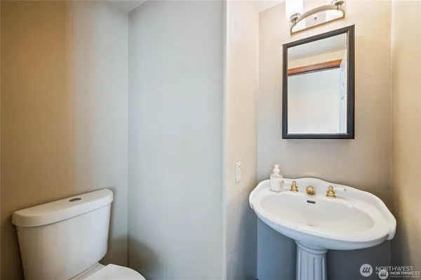 a view of a hallway to a livingroom with furniture cabinet and mirror