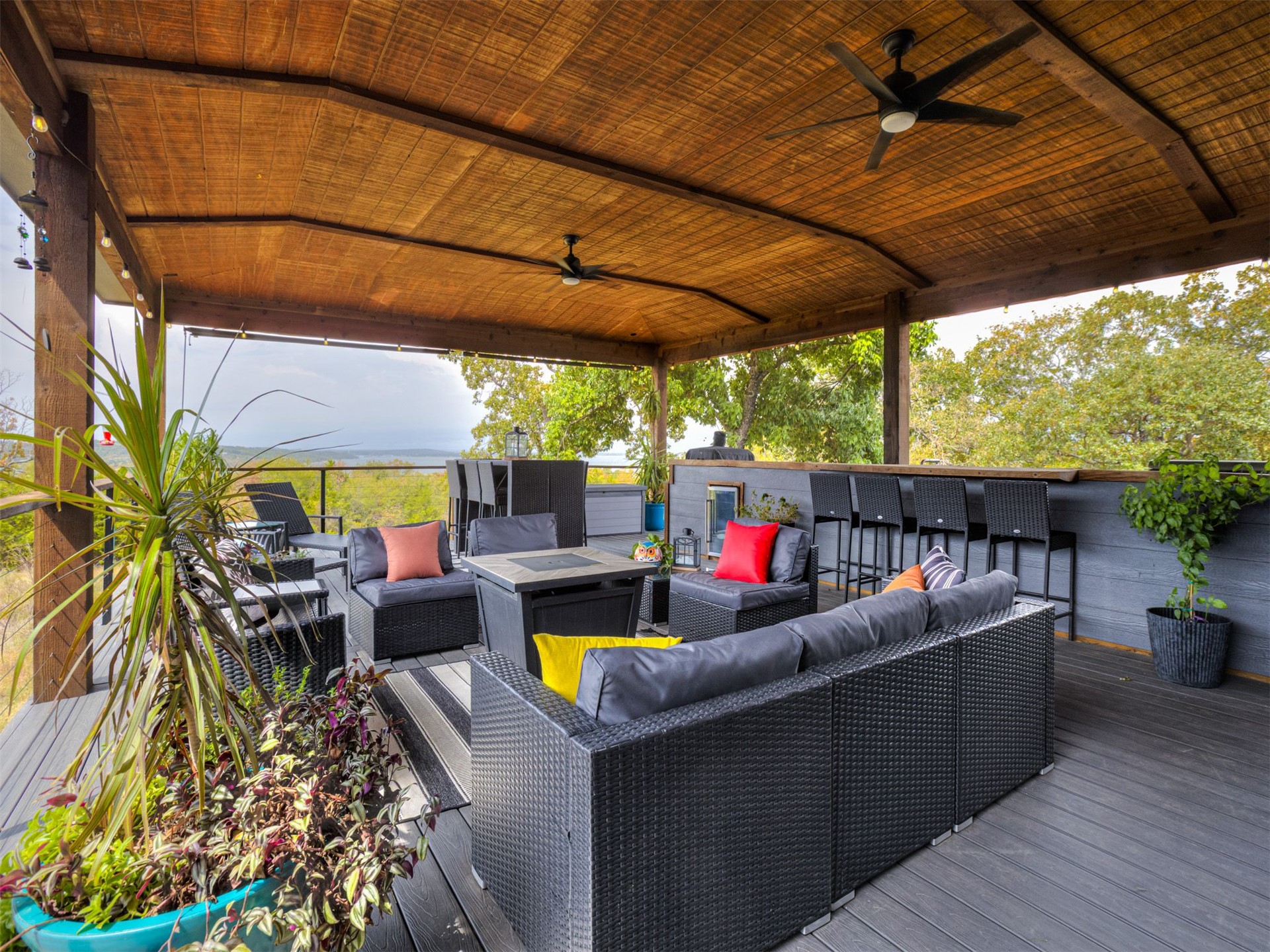 1073 Hidden Ridge Road Stigler, OK 74462 - Photo 26 of 56 Expansive outdoor living area featuring a vaulted wood-finish ceiling, dark composite decking, and a built-in bar with seating