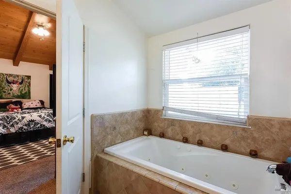 a bathroom with a bathtub and next to a window