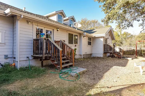 a view of a house with a yard and wooden fence