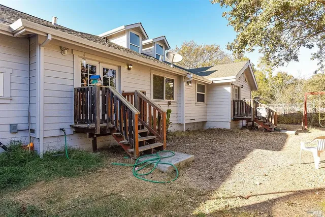 a view of a house with a yard and wooden fence