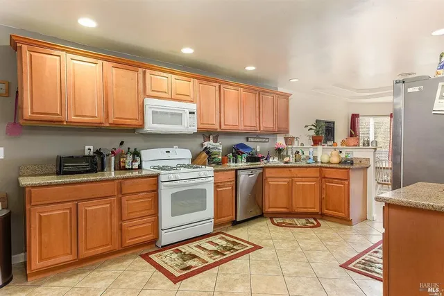 a kitchen with stainless steel appliances granite countertop a stove top oven a sink and cabinets