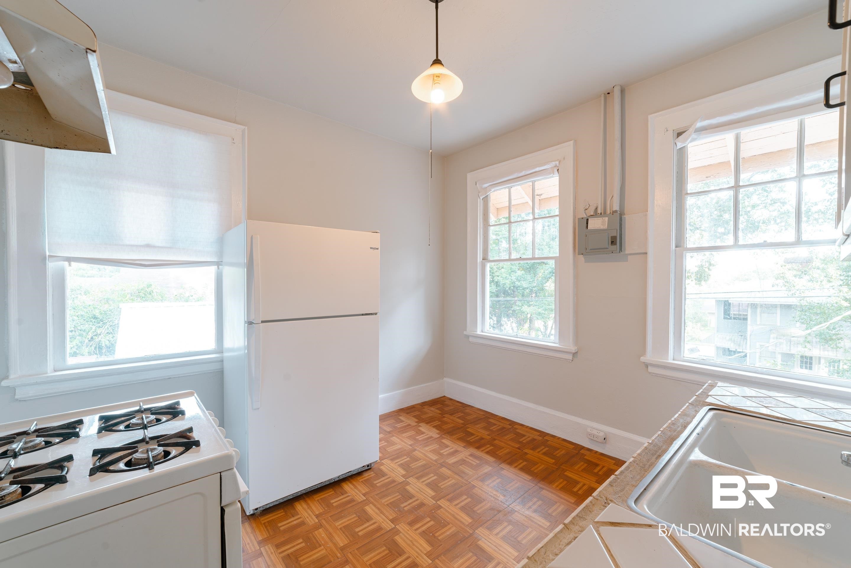 312 1st Street Mobile, AL 36611 - Photo 13 of 29 Kitchen featuring parquet flooring, a wealth of natural light, pendant lighting, and white appliances