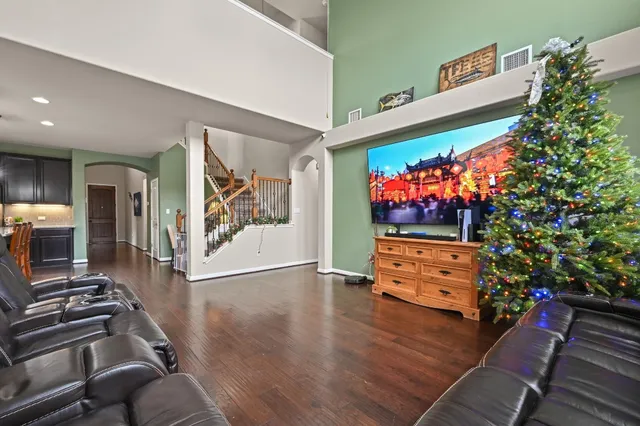 an empty room with wooden floor cabinet and a flat screen tv