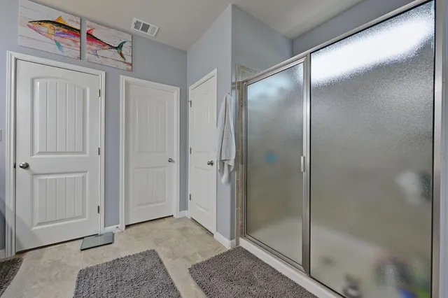 a spacious bathroom with a shower and a glass door