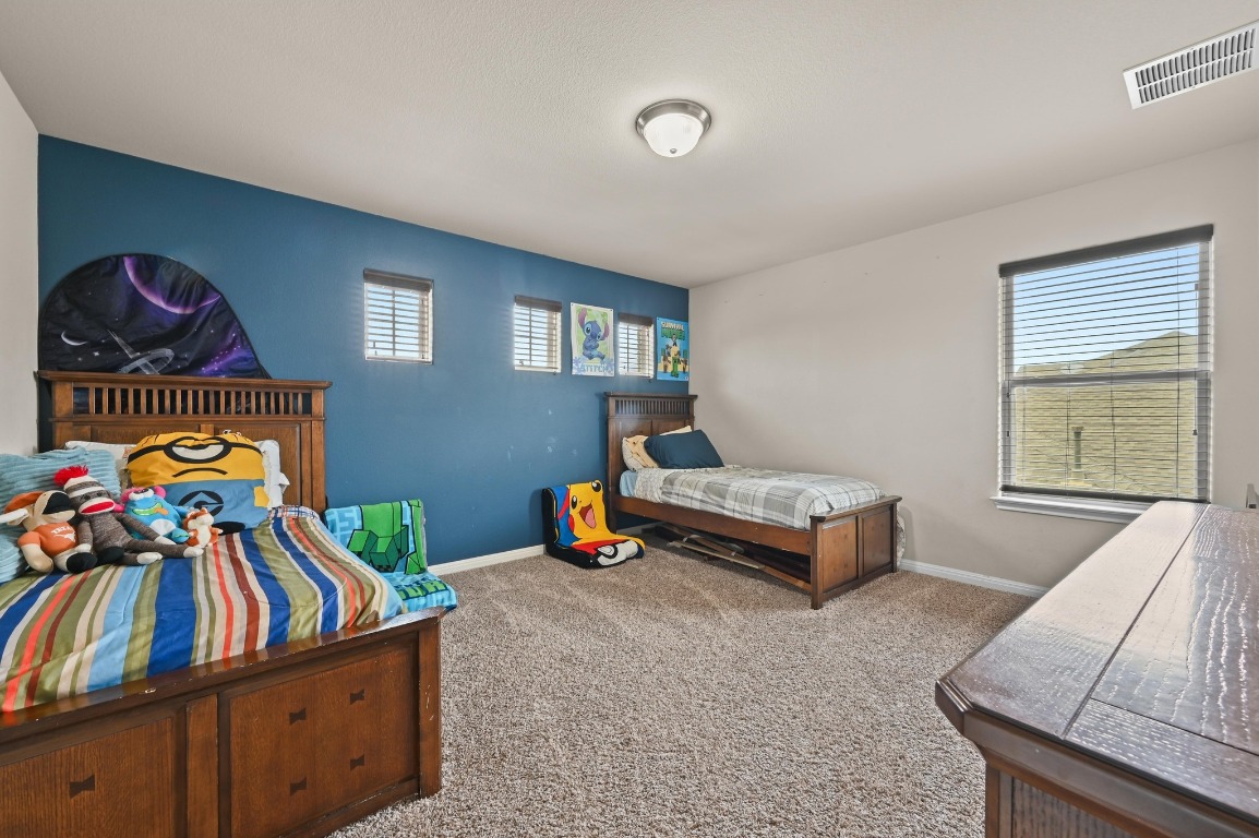154 Pettigrew Path Buda, TX 78610 - Photo 26 of 36 a bedroom with furniture and a window