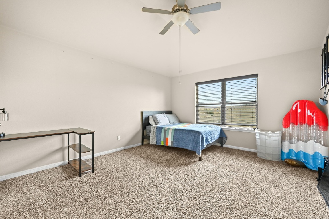 154 Pettigrew Path Buda, TX 78610 - Photo 27 of 36 a bedroom with a bed and a window