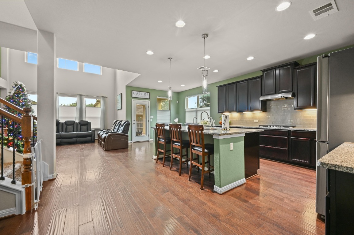 154 Pettigrew Path Buda, TX 78610 - Photo 7 of 36 a kitchen with lots of counter top space and living room