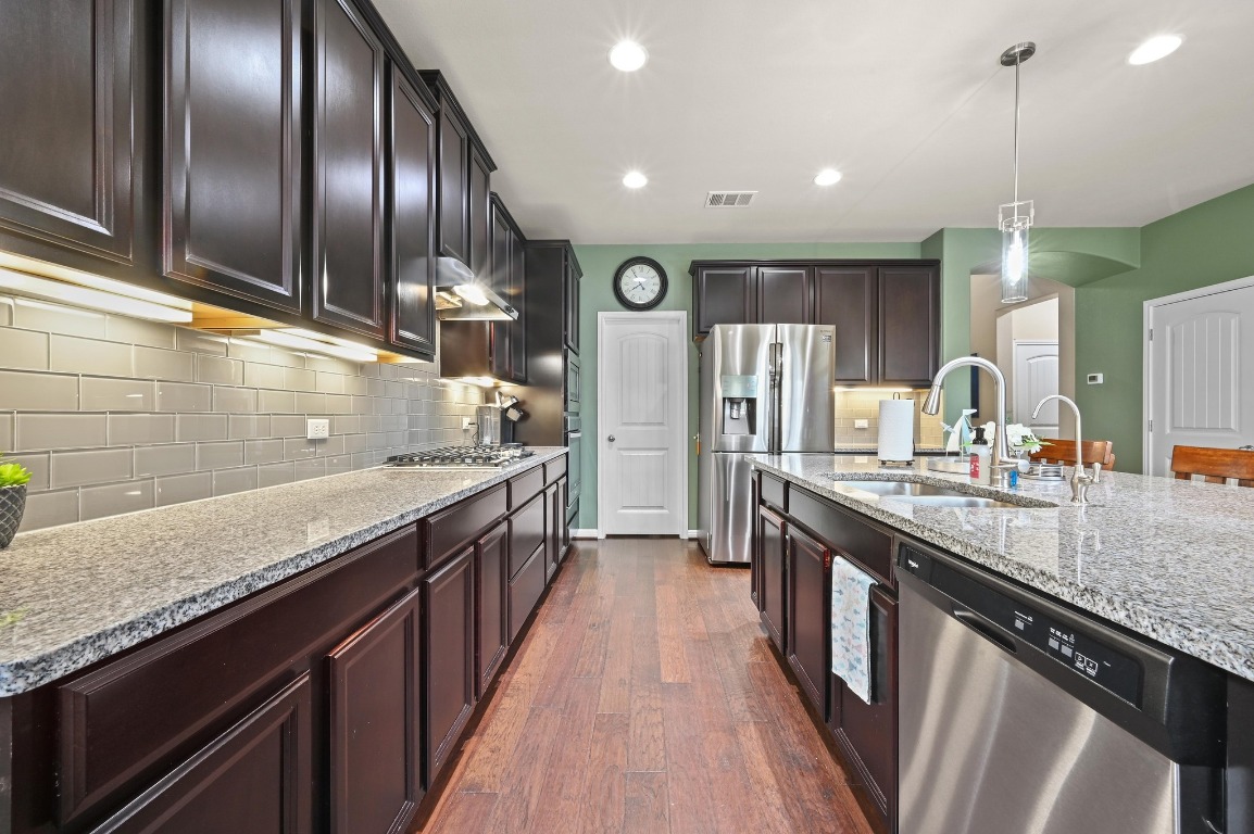 154 Pettigrew Path Buda, TX 78610 - Photo 9 of 36 a large kitchen with granite countertop counter space a sink and stainless steel appliances