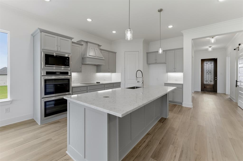 906 Perrin Lane Van Alstyne, TX 75495 - Photo 14 of 30 a kitchen with kitchen island white cabinets and stainless steel appliances